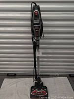Front view of the Shark Rocket HV380 vacuum cleaner standing upright on a white cloth with cord wrapped around the handle.