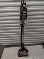 Full view of the Shark Rocket HV 380 upright vacuum cleaner standing on a white towel with cord wrapped