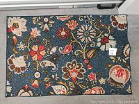 Top-down view of the rectangular navy blue area rug with intricate floral and paisley designs in multiple colors.