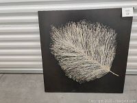Front view of the square canvas painting showing a large cream-colored leaf on black background, condition and dimensions clear.