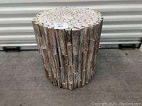 Front view of the decorative wood end table showing the rustic, vertically arranged wood pieces and the round top.