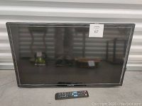 Front view of the 32-inch Samsung smart TV with remote control placed in front.