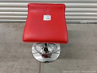 Top view of red padded bar stool seat with sticker number