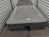 Intex full size air mattress fully inflated and viewed from front side, showing its size and texture.