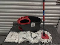 Overall view of four microfiber mop heads, mop with extendable handle, and bucket with foot wringer