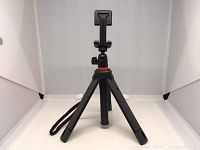 Front view of Joby TelePod Mobile selfie stick in tripod mode showing three foldable legs and smartphone mount.