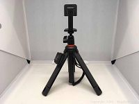 Joby TelePod Mobile selfie stick fully extended into tripod mode with phone holder mount and remote shutter attached.