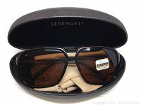 Serengeti sunglasses folded and resting inside black hard case with Serengeti branding, cleaning cloth visible.