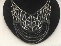 Front view of Swarovski necklace showing crystal design and black chain tassels.