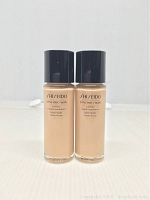 Front view of two bottles of Shiseido Synchro Skin Lasting Liquid Foundation showing the product name and packaging details.