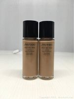 Front view of two bottles of Shiseido Synchro Skin Lasting Liquid Foundation Neutral 4 with black caps, showing product name and details