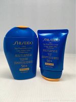 Shiseido Ultra Sun Protection Lotion and Cream side by side on white background, showing front product labels.