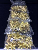 Four sealed packages of approximately 25 gold star pins each, clear plastic packaging with 'Made in Taiwan' text visible.