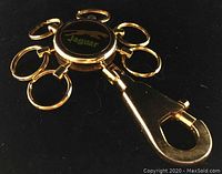 Front view of circular Jaguar logo keychain with six autonomous gold key rings attached and a large clasp.