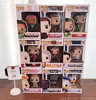 Front view of nine boxed Funko Pop figures displayed in three rows of three, showing character names and numbers.