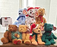 Front view of all 7 TY Beanie Baby bears arranged in two rows showing their Christmas-themed designs and tags.