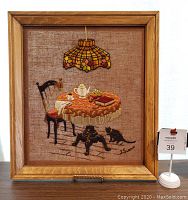 Front view of the framed vintage crewel embroidery showing lamp and cats at the tea table.