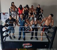 Full view of WWE Tough Talkers wrestling ring with nine WWE wrestling action figures positioned inside and around the ring, figures in varying costumes.