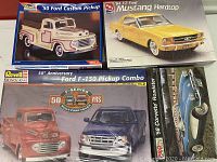 Five classic car plastic model kits in original packaging, including 1950 Ford Custom Pickup, 1964 1/2 Ford Mustang Hardtop, 1958 Corvette Roadster, and Ford F-150 combos.