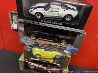 Stacked boxed cars: Ford GT, Harley-Davidson F-150, VW New Beetle, red convertible