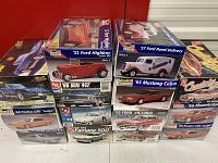 Lot overview showing stacked boxes of model car kits with visible titles and artwork of classic American cars