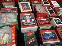 Overview of many Hallmark Keepsake Christmas ornaments in boxes featuring classic car models and other figures.