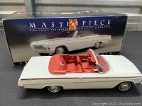 White plastic model convertible car with red seats and steering wheel displayed beside original Masterpiece box.