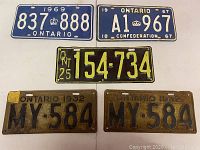 Overview of all five Ontario license plates laid out on white surface