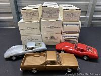 Photo of all three plastic model cars and their original boxes stacked behind them.