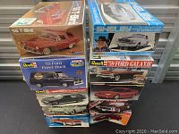 Stacked view of plastic model car kit boxes showing various vintage models including '56 T-Bird, '66 Mustang GT350, '55 Ford Panel Truck, and others.
