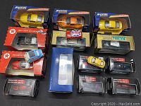 Overview of the lot showing multiple boxed die cast cars and some loose in original or damaged packaging.