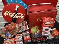 Wide view of all lot items on table including cooler, sign, trays and boxed vehicles