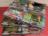 Photo showing a group of six boxed die-cast car activity sets from American Muscle BodyShop series, including Roscoe's Sheriff Cruiser, '69 Ford Mustang, and others.
