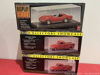Front view of three Revell display case boxes stacked with visible model cars inside.