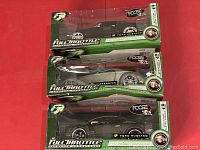 Three Full Throttle Foose die-cast Ford Mustang replicas in original green window box packaging.