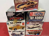 Stacked view of packages showing Mustang Cafe Racer, Those Famous Fords Cougar II, AMT '61 Ford, AMT '53 Ford Pickup, Revell '55 Chevy, AMT '72 Pontiac GTO, AMT 1969 Hurst Olds boxes