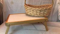 Photo showing the lap tray with foldable legs and the woven basket placed on top.
