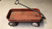 Side angled view of the vintage red Radio-Pal wagon showing the body and pull handle.