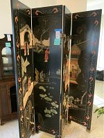 Front view of four-panel black oriental room screen with colorful painted scenes including traditional buildings, people, trees, and lotus flowers on front panels.
