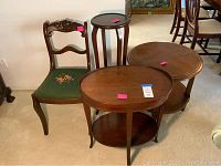 Full view of all items: round and oval side tables, plant stand, and wooden chair with green floral seat.