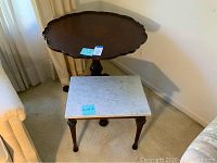 Image showing both vintage round pedestal table and rectangular table with stone top, positioned side by side.