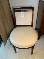 Full front view of the wooden side chair showing upholstered seat and backrest