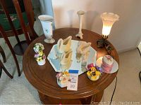 Table displaying all items together with visible Lenox pedestal vase, swan figurines, floral decor pieces, and hand-painted vases.
