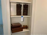 Three wooden boxes; largest with decorative inlay on lid, medium box and a small box on a shelf.