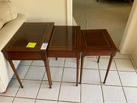3 wooden nesting side tables lined up next to couch showing full set and size relation