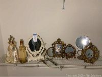Religious figurines with tabletop framed mirrors and crucifix crosses arranged on a wire shelf.