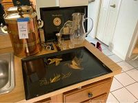 Overview of ice bucket, trays, shot glasses, and pitcher on counter