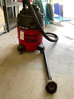 Full front view of red and black Shop Vac with hose and attached round brush, showing '1.75 Peak H.P.' and '10 gallon' label.