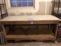 Full view of the workbench table showing wood top with steel frame and lower wood shelf.
