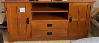 Front view of the hardwood office credenza showing two side cabinets with doors, three open shelves and two drawers in center.